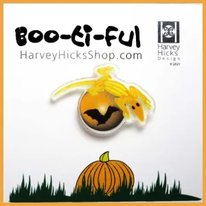Halloween pin featuring an illustration of a  lizard crawling over the moon